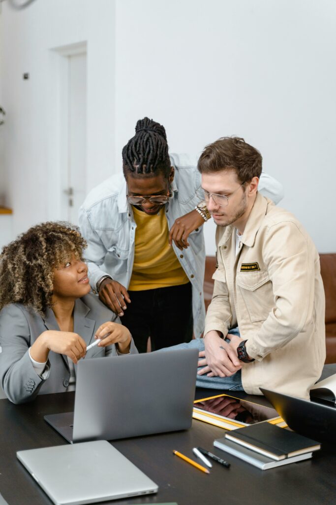 Groupes de personnes en discussion dans un cadre professionnel, illustrant la collaboration et la formation comme alternatives au modèle d'agence classique.